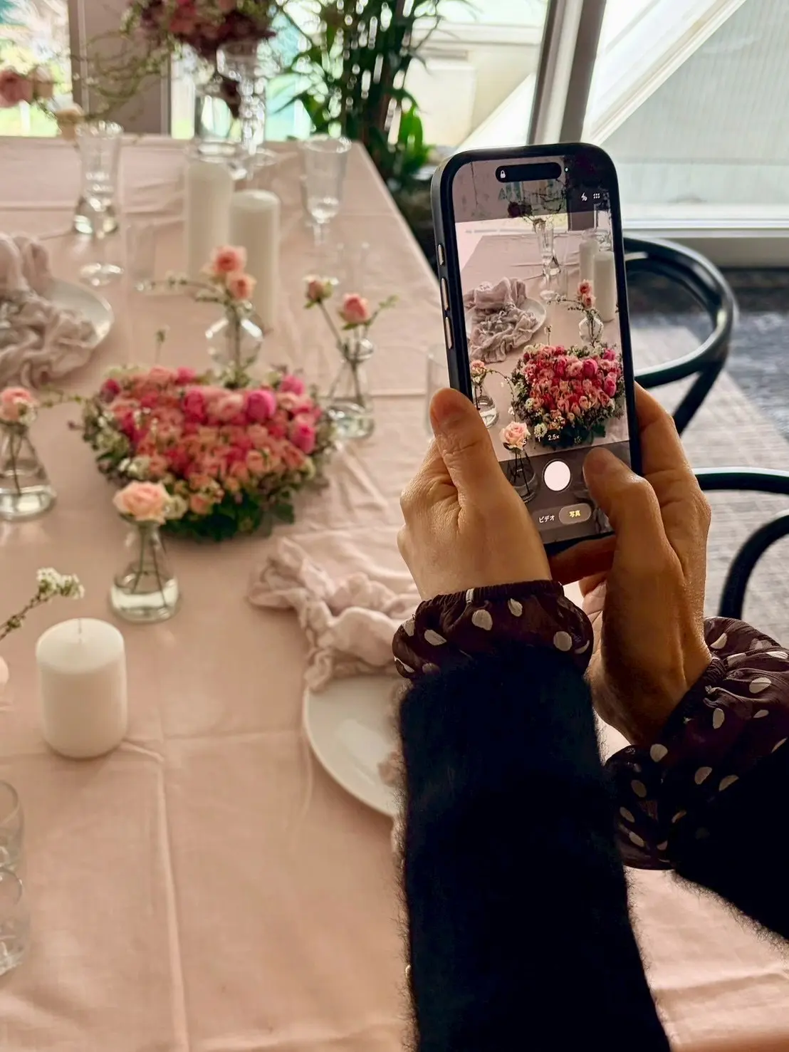 パリスタイルのバラのハート型アレンジメントの写真を撮る女性