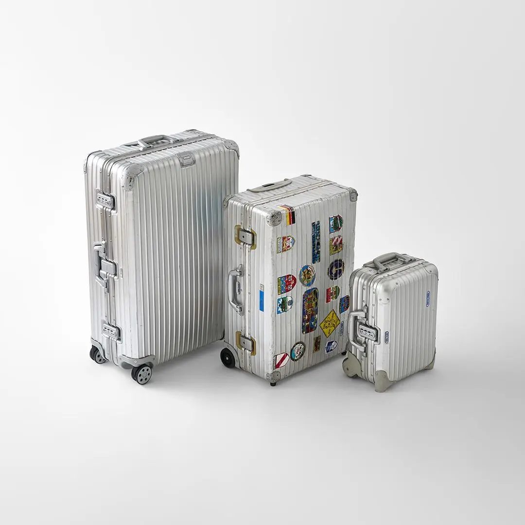 リモワのアルミ製スーツケース3つが並ぶ写真。左からTOPAS 77 MW (2013 年製)、JUMBO TROLLEY OPAL ’63 (2002 年製)、TOPAS MINI TROLEY (2008 年製)