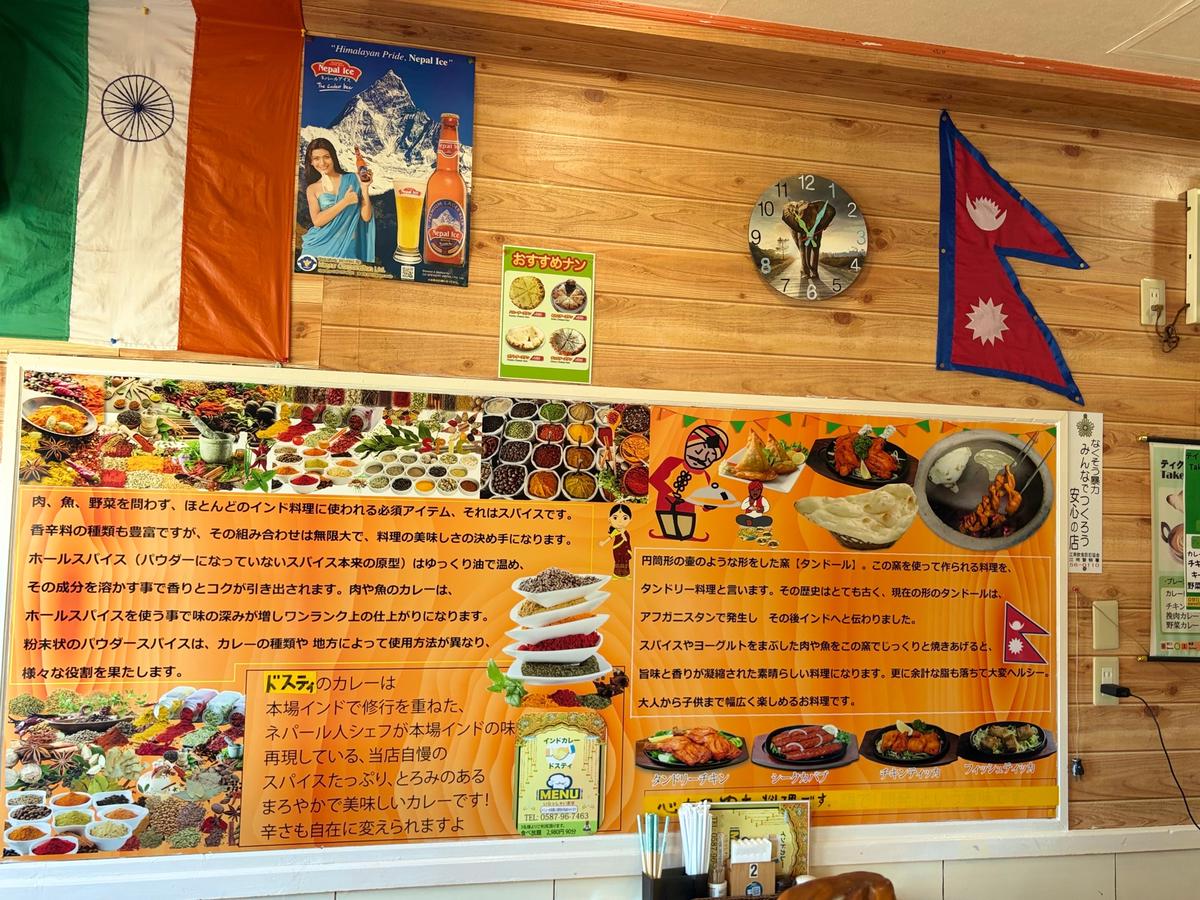ネパール風アイスクリームの屋台。カラフルな装飾やメニュー、アイスクリームの盛り合わせが並び、ネパールの風景写真や説明書きが添えられている。