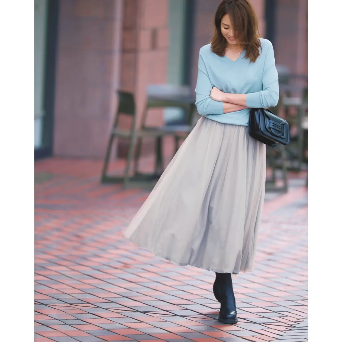 ライトブルーのVネックニットにライトグレーのチュールスカートを合わせたコーディネート　モデル・SHIHO