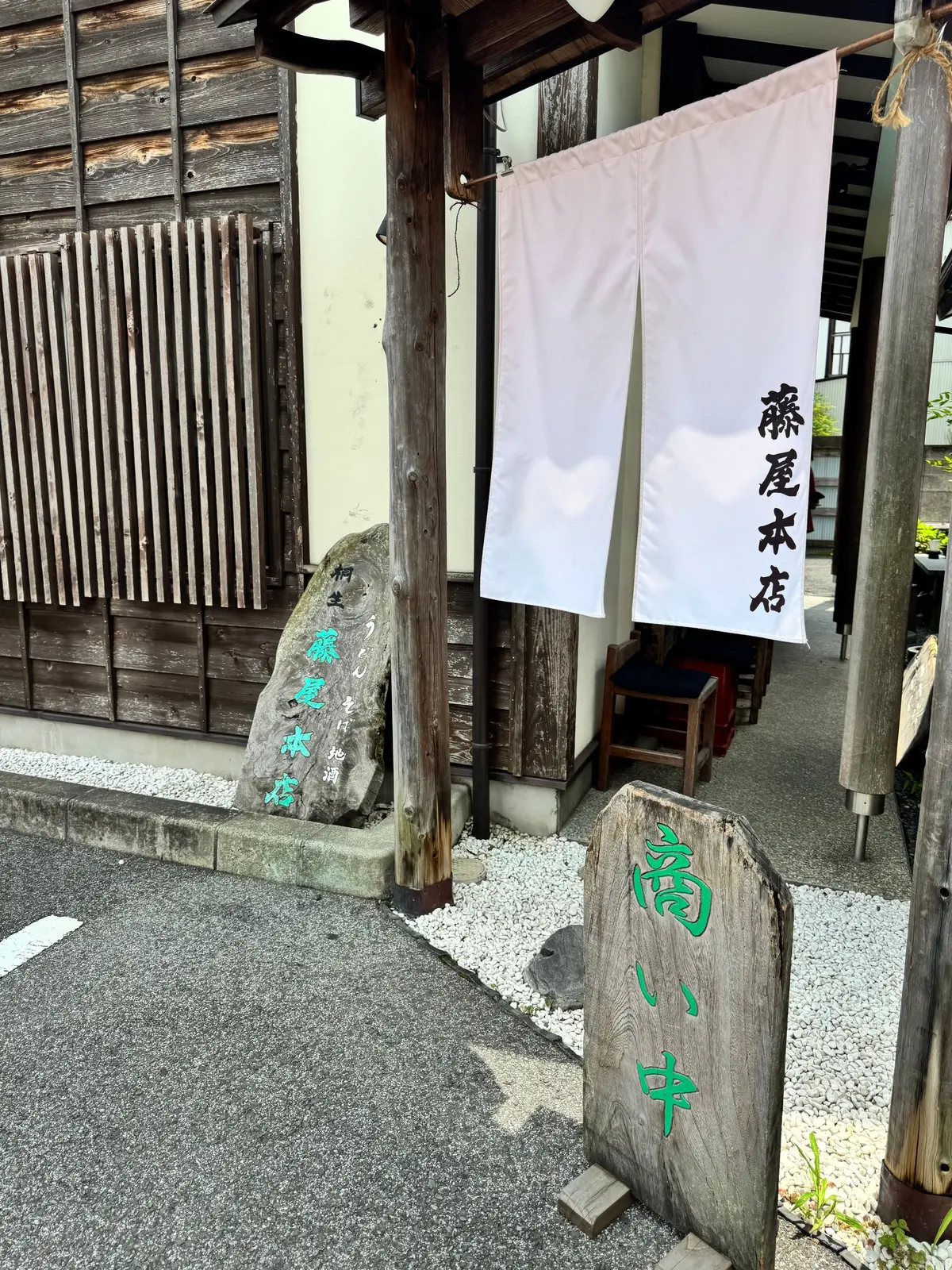 木造建築の店先に、白い提灯と木製の看板が置かれている様子。看板には緑色の文字で「菊い舟」とあり、提灯には縦書きで店名が書かれている。背景には木製の格子戸が見える。