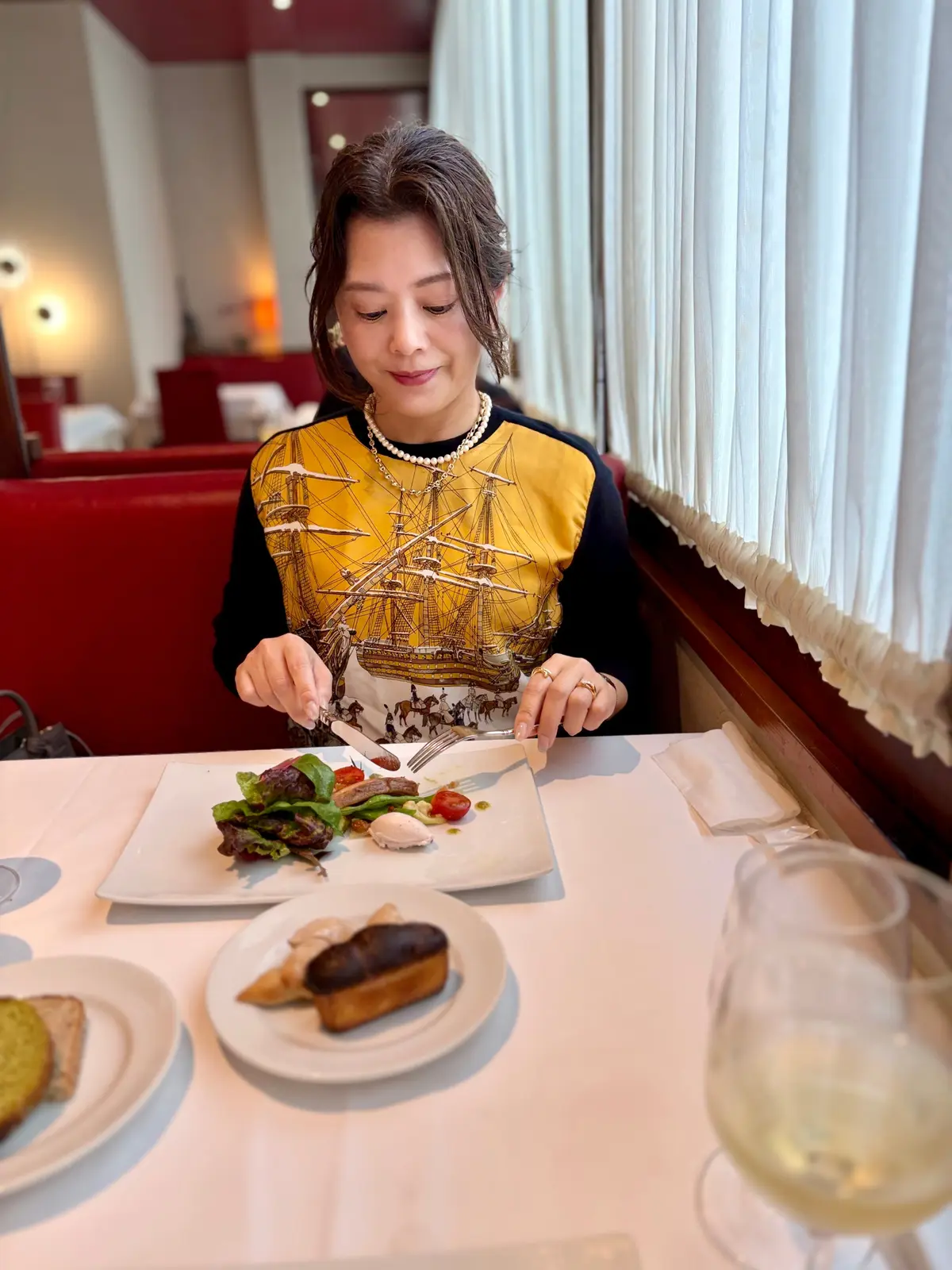 50代女性 ディナーコーデ 上半身 パールネックレス スカルチェーン エルメスニット 食事シーン 上品スタイル