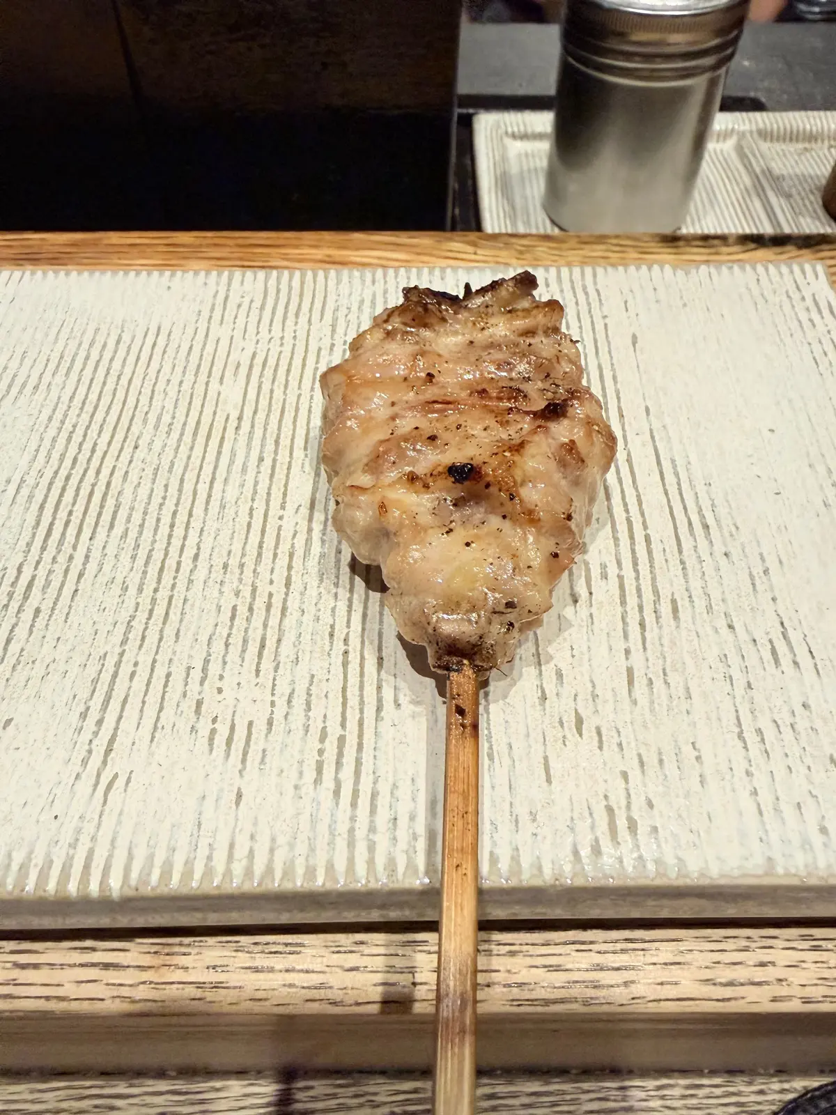 焼き魚の串焼き、木の串に刺さった焼き魚が木製のトレイに置かれている