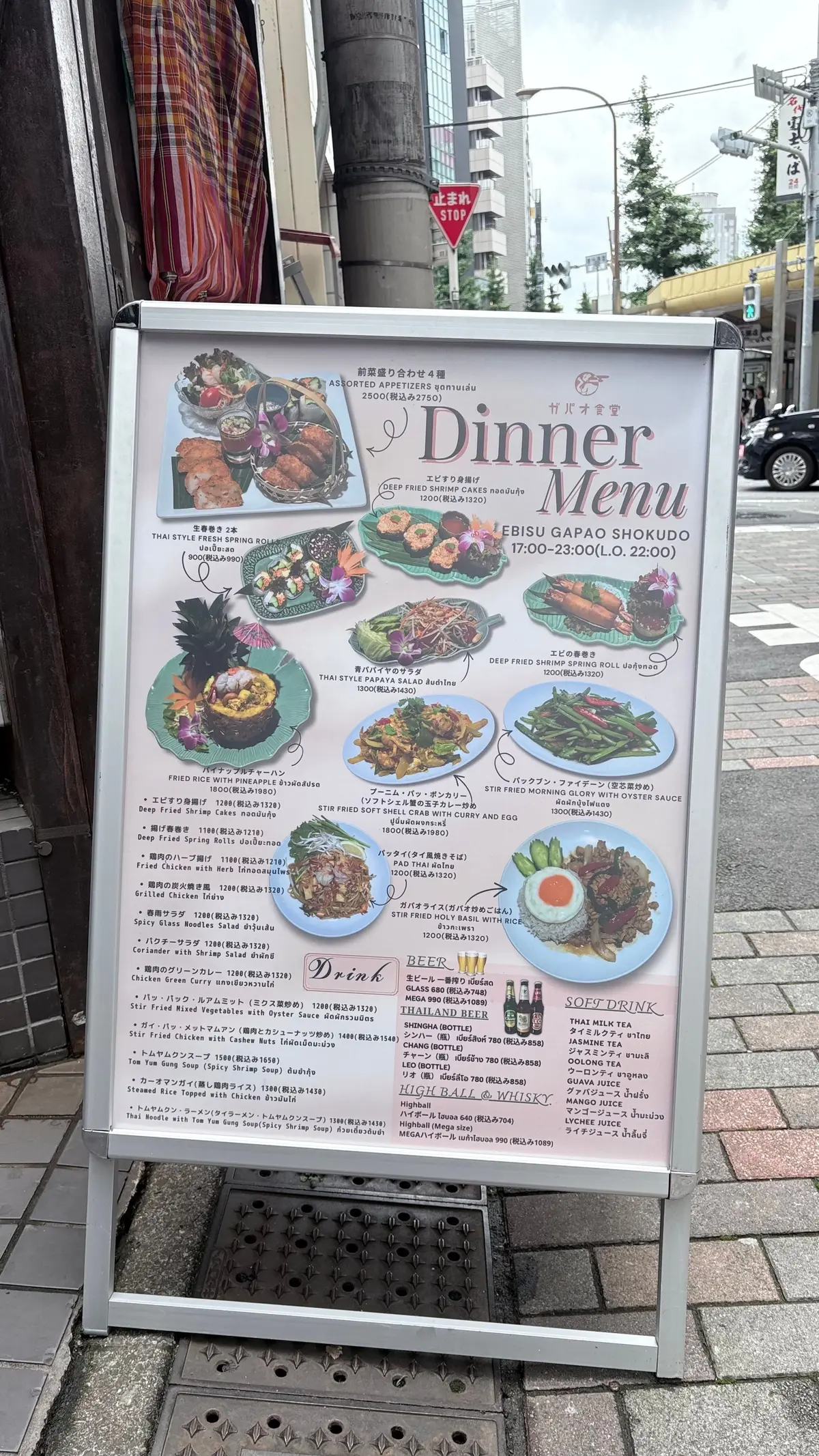 夕食メニューが掲示された看板。右上に「EBISU GAPAO SHOKUDO」のロゴ、下部中央に「Dinner Menu」の文字。メニューにはタイ料理の料理名と価格が記載され、料理のイラストも添えられている。