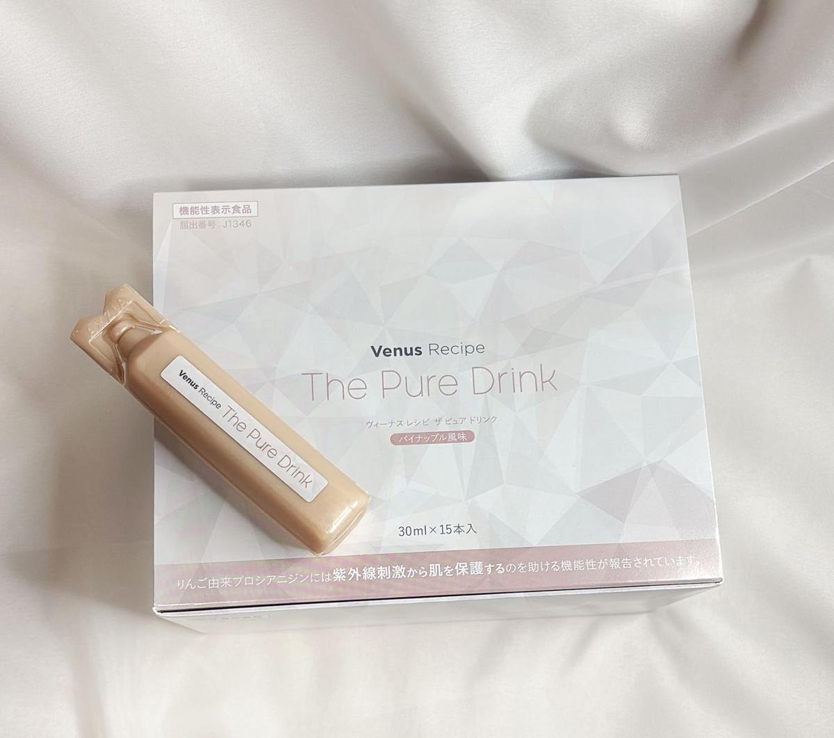白い箱に入った「Venus Recipe The Pure Drink」のドリンクセット。箱の前面中央に商品名が記載され、右下には30ml×15本の記載がある。箱の左にはドリンクボトルが置かれている。