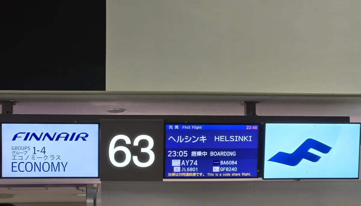 フィンエアーの航空便情報表示板。ゲート番号は63、目的地はヘルシンキ。23時05分から搭乗開始。AY74、JL6801、BA6084、QF8240の便名が表示されている。