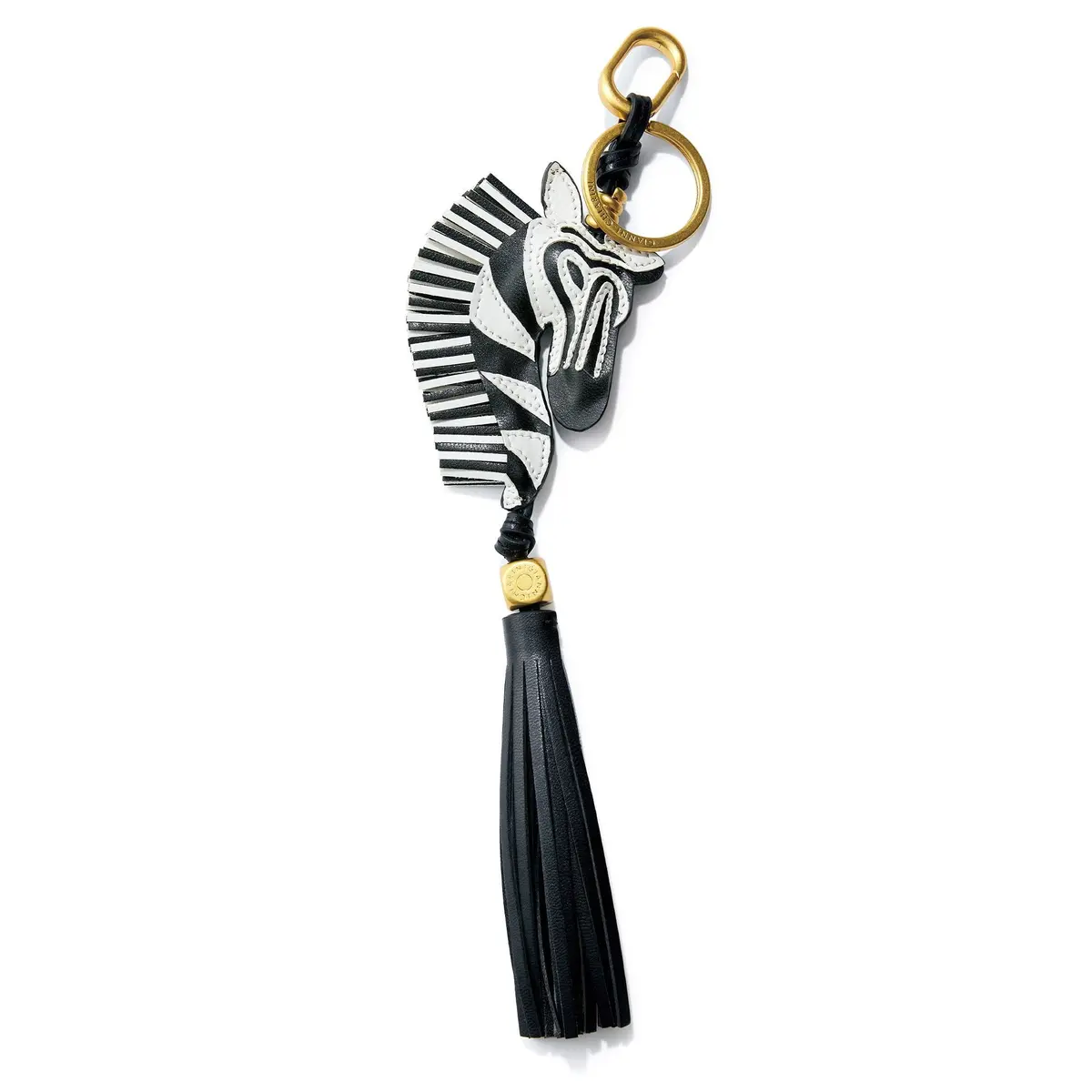 デルヴォーのキーホルダー。白地に黒の縞模様のゼブラモチーフで、金色の金属製のリングが付いている。下部には黒い革製の房が垂れ下がっている。