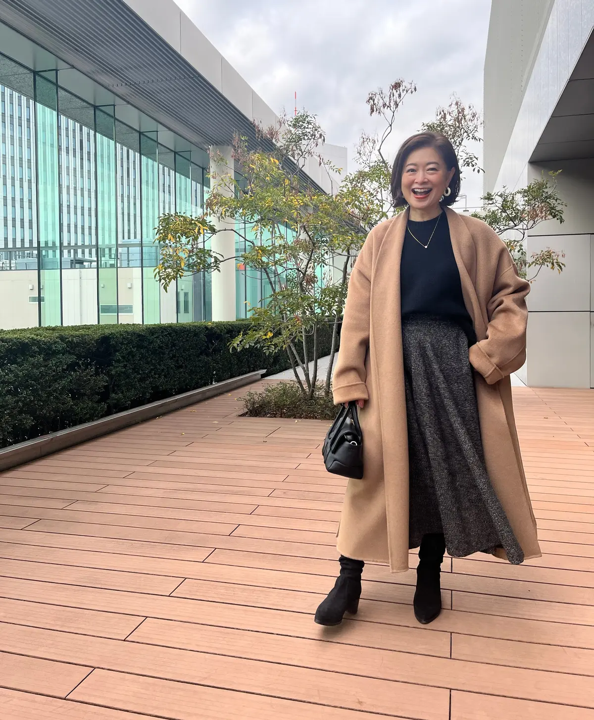 三尋木奈保さん、ベージュコート×黒コーデ コート・スカート／CHIEKO＋　ニット／ギャルリー・ヴィー　バッグ／トッズ　靴／ファビオ ルスコーニ