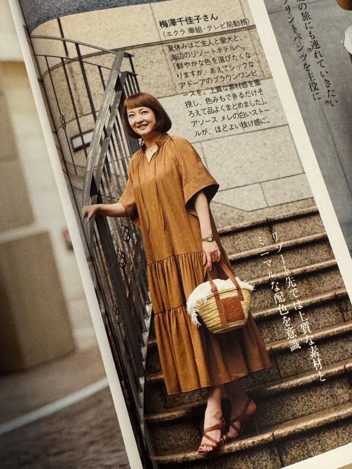 ベージュのトレンチコートを着た女性が、杖をつきながら歩いている全身写真。背景には石造りの建物が見える。右上にテキストボックスがあり、女性の名前と簡単な紹介文が書かれている。