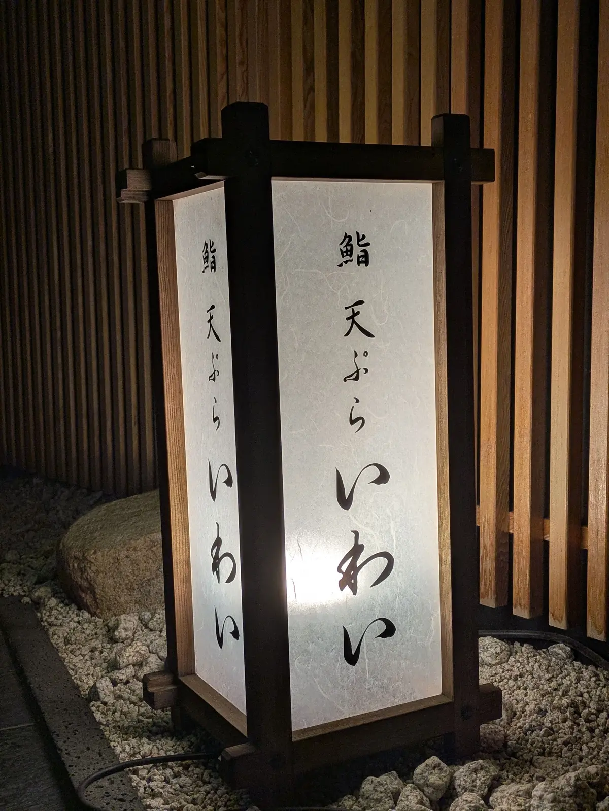木製の灯篭に「光天井」の文字が書かれ、石の周りに配置された和風の照明
