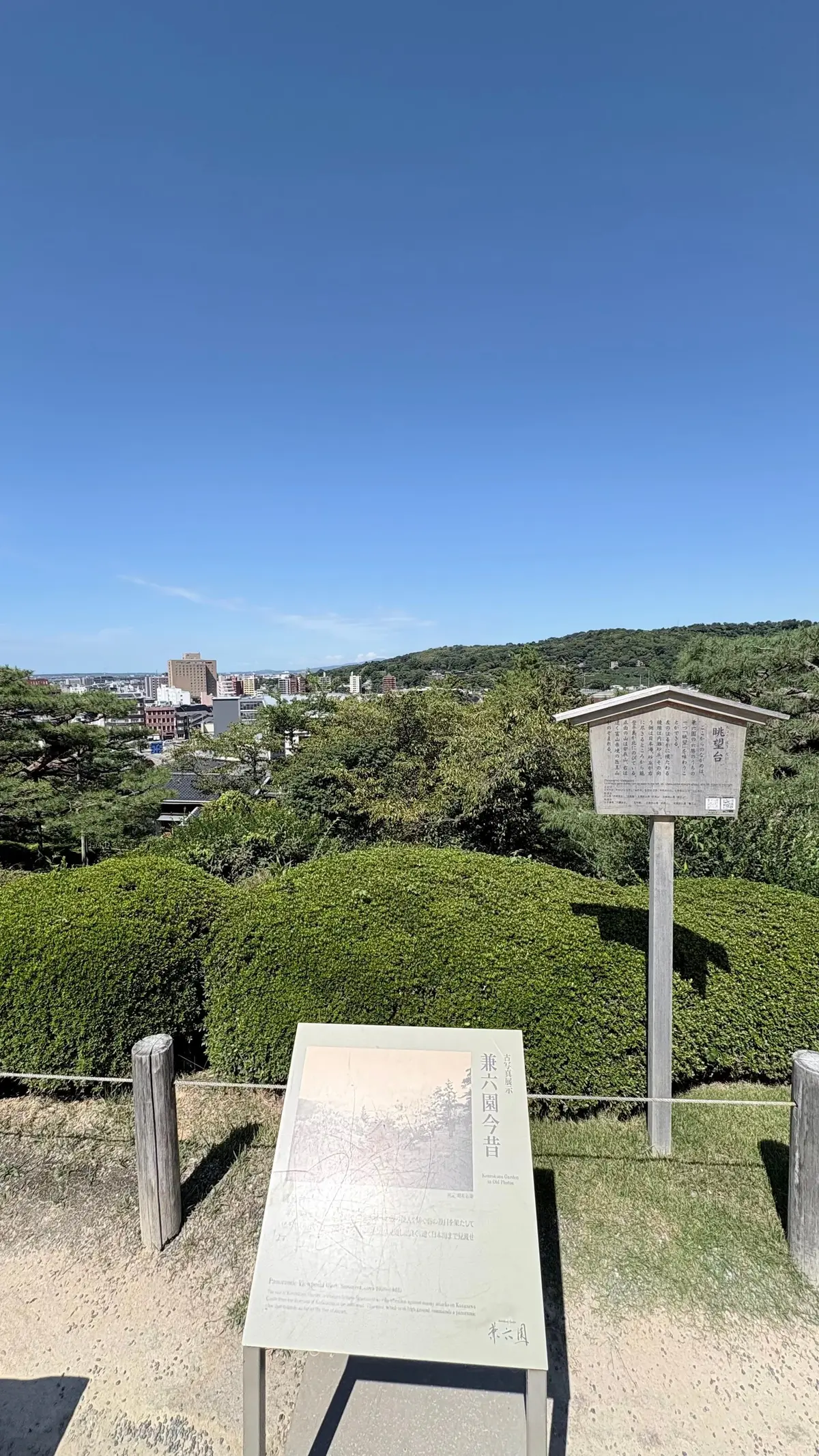 駅構内の階段付近。エスカレーターと階段があり、人々が利用している。上部には「Welcome to HOKURIKU」の看板と、赤い桜のイラストが描かれた横断幕が掲示されている。