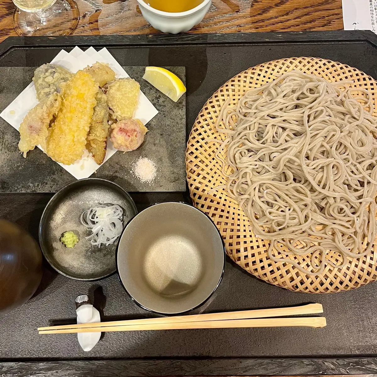 天ぷら、うどん、ワサビ、醤油、ネギ、わさびの小皿が並んだ料理プレート