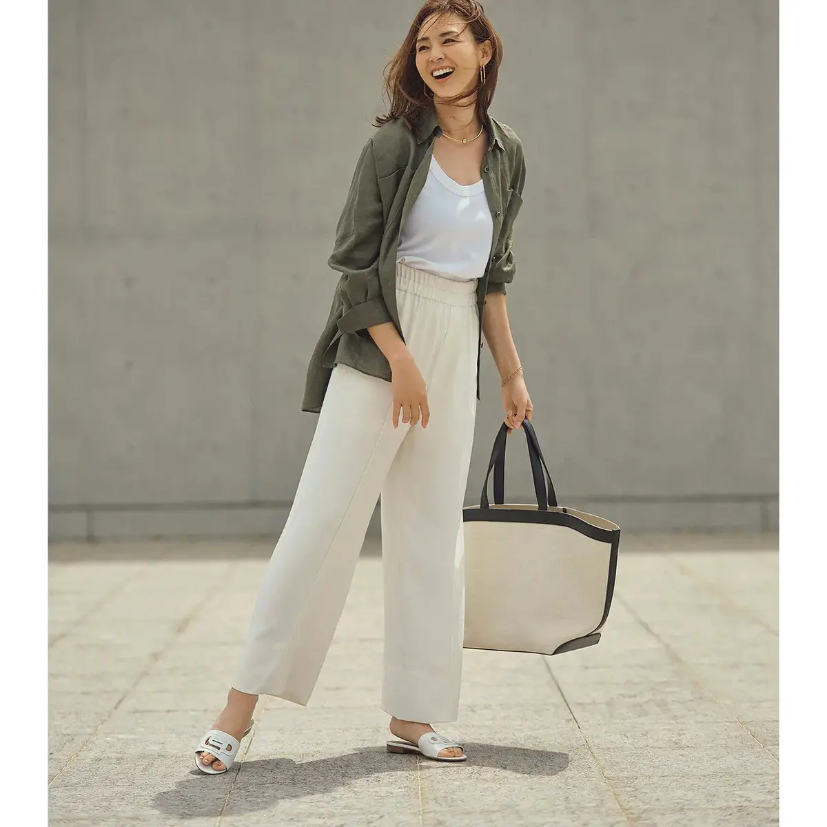 アクティブなパンツスタイルも柔和な白なら、女性らしい