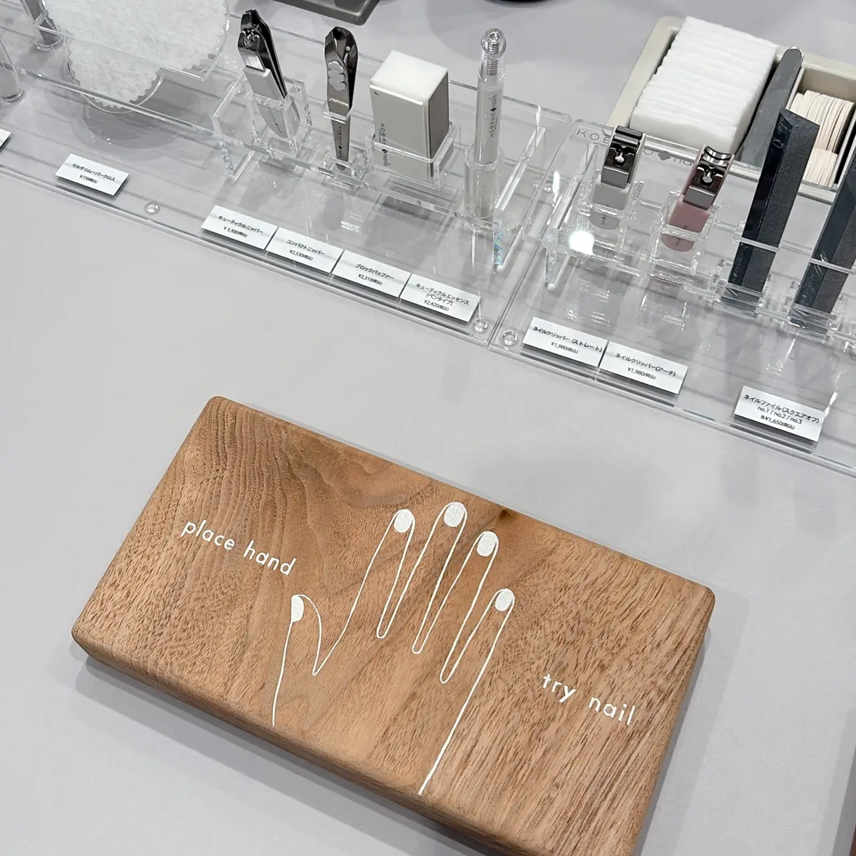 ニュウマン高輪　「ウカ ストア ケア アンド シェア」は、ウカ初のネイルケア専門サロン併設のストア　アイテムをお試しできるカウンターには、ちょっとなごめる木製のプレートが。ウカならではのパーツケア愛がストアの随所にあふれています