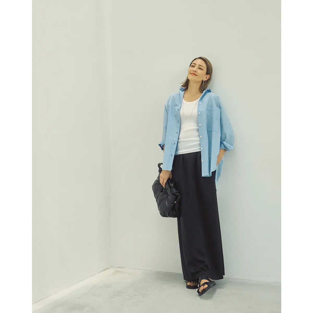 白タンクトップにブルーシャツ、黒のワイドパンツのコーデを着たモデル・RINA