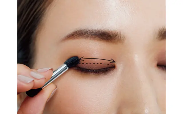 パレットのブラウンの締め色を、目頭から目じりのきわにオン。アイホール半分まで何度か往復させて、ぼかし込みながら入れる。