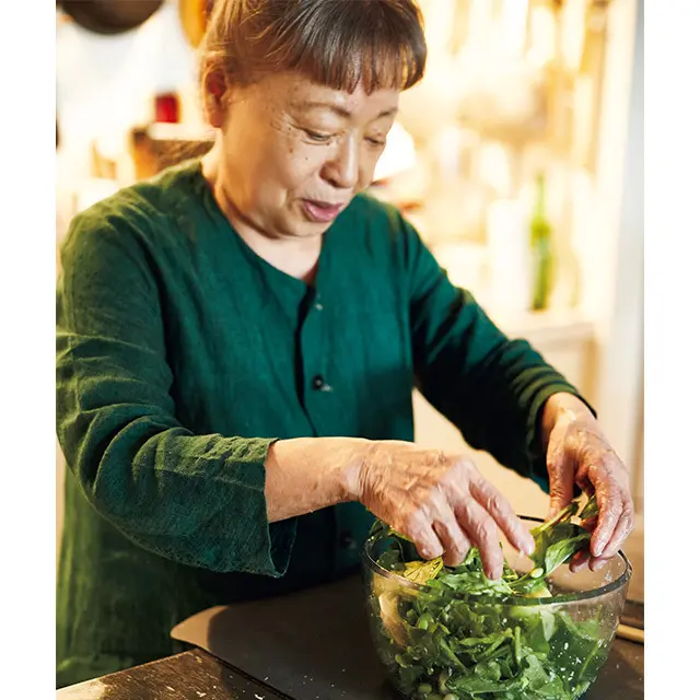 サラダを仕上げるひでこさ ん。おもてなしのときは下ごし らえをしっかりと。事前に野菜 などの材料はカットし、料理ごと にまとめて冷蔵庫に入れておく
