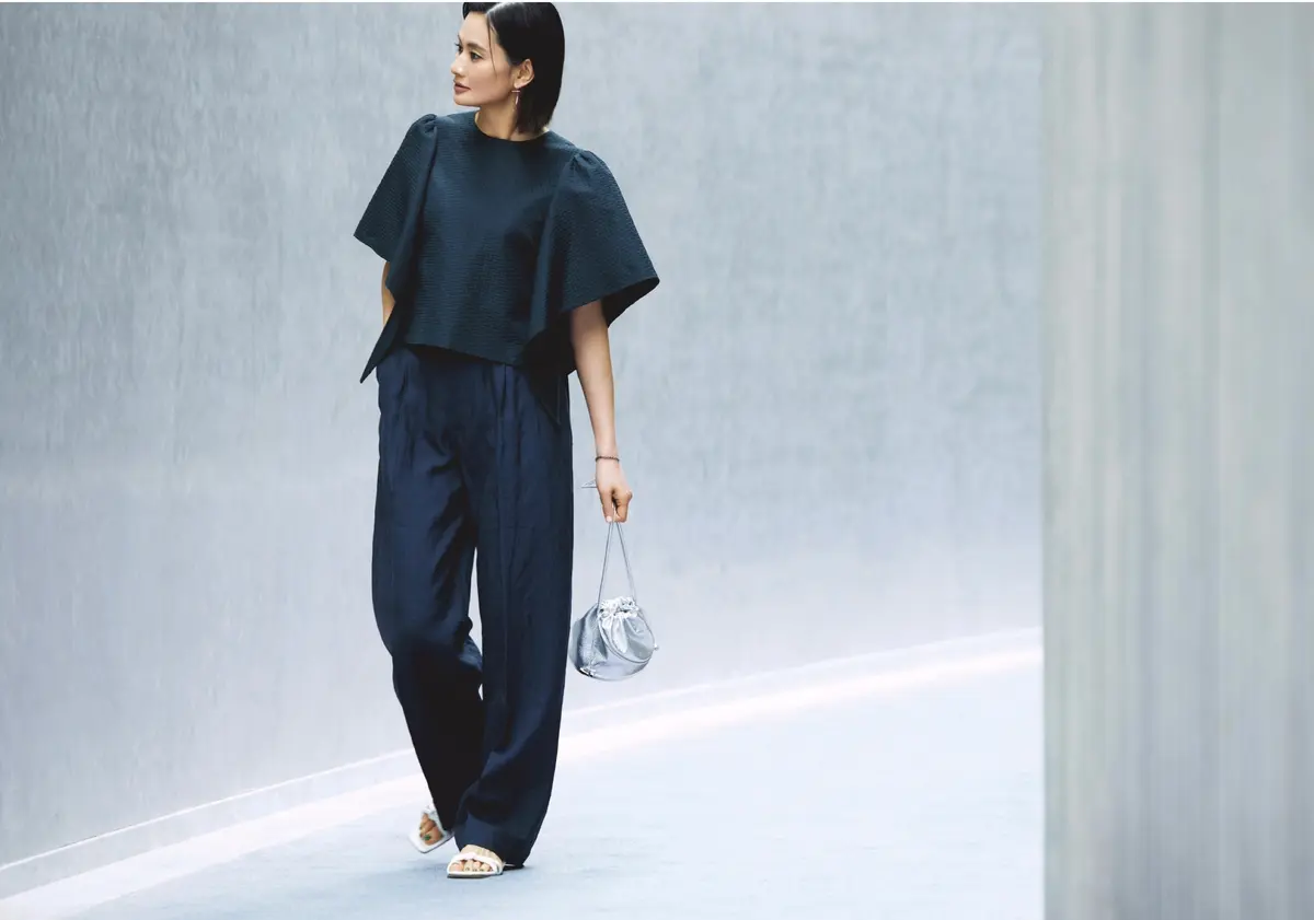 黒ボリュームスリーブトップスにネイビーのタックパンツを合わせたコーディネート　モデル・渡辺佳子