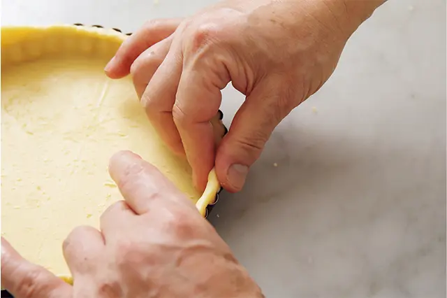 上からはみ出したところを下に押し、側面の生地を少し厚くする。