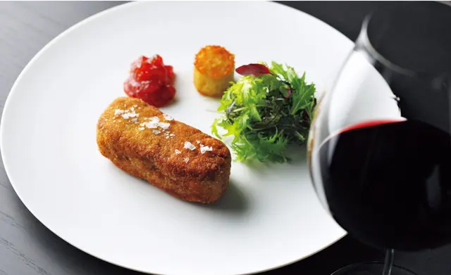 「仔牛のカツレツ ミラノ風 オレンジとバジルが香るトマトのマルメラータを添えて」。イタリア産の仔牛の繊細な肉質を味わえる、厚みのあるスタイルで