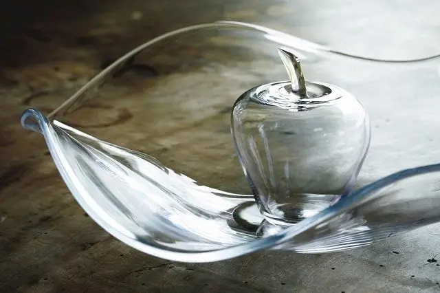 漆作家である父・睦美さんが得意とした優美な曲線をガラスで表現した大鉢にリンゴのオブジェを飾って