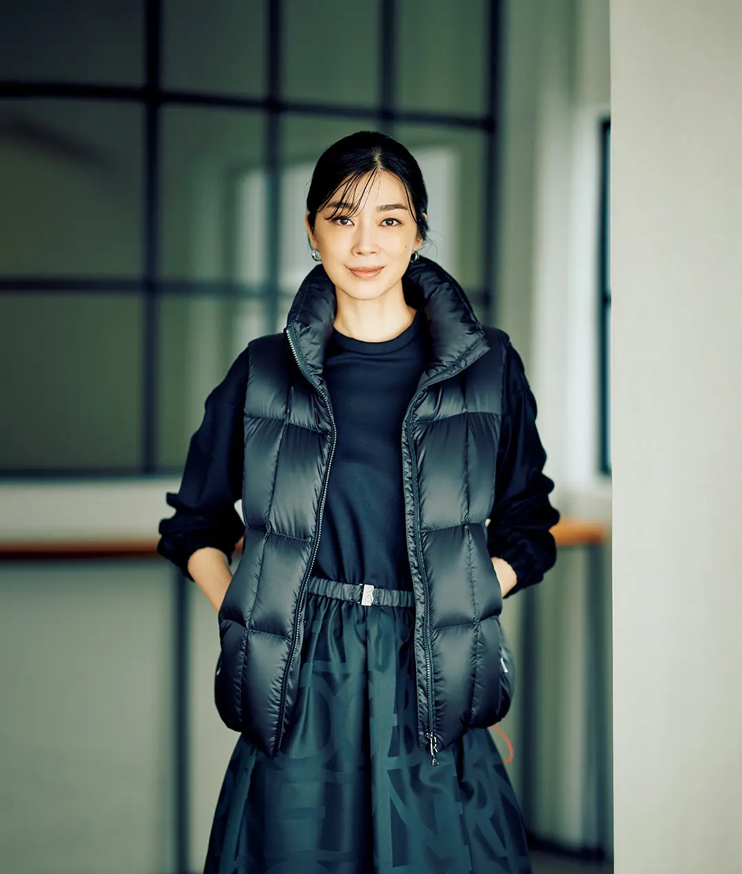 光を集めるブラックベストが装いをシックに引き締める