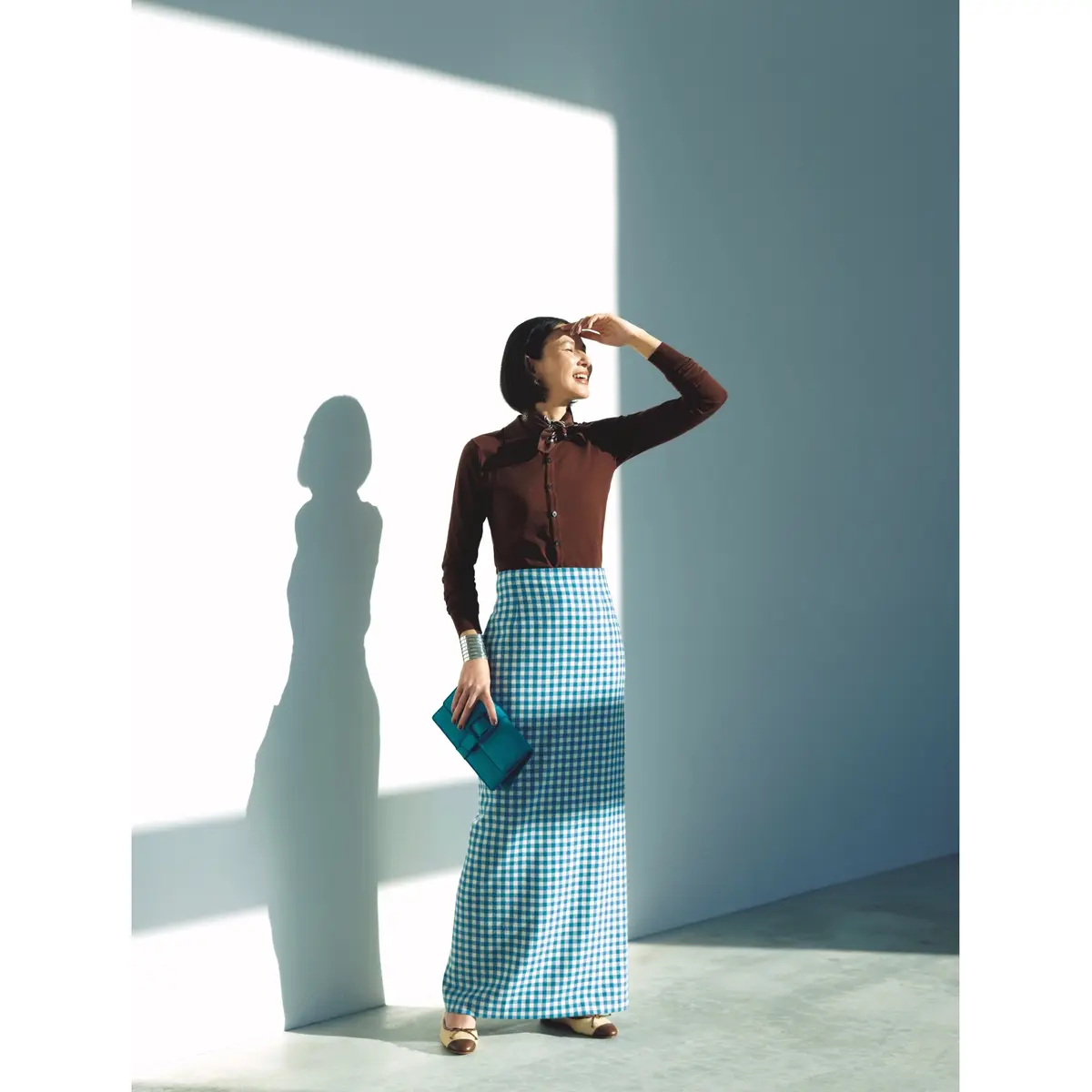 ブラウンポロニットとブルーギンガムチェックスカートのコーディネート　モデル・田沢美亜