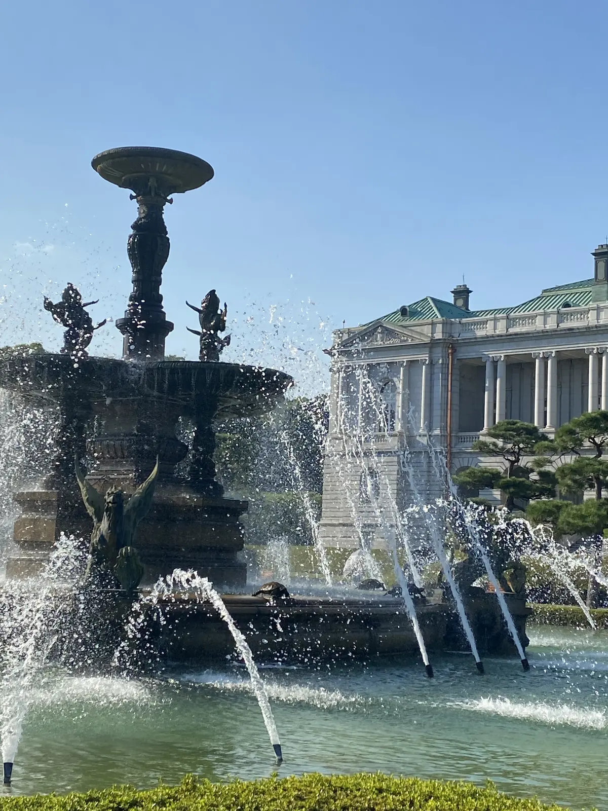 迎賓館の噴水の彫刻と水しぶき。日差しに照らされてきらめいている様子。