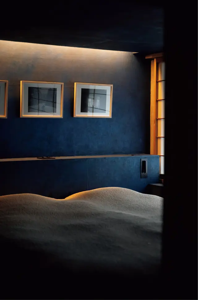 DELTAの宿泊施設。京都在住の和紙作家ハタノワタルの和紙がはられた壁に写真作品が飾られる