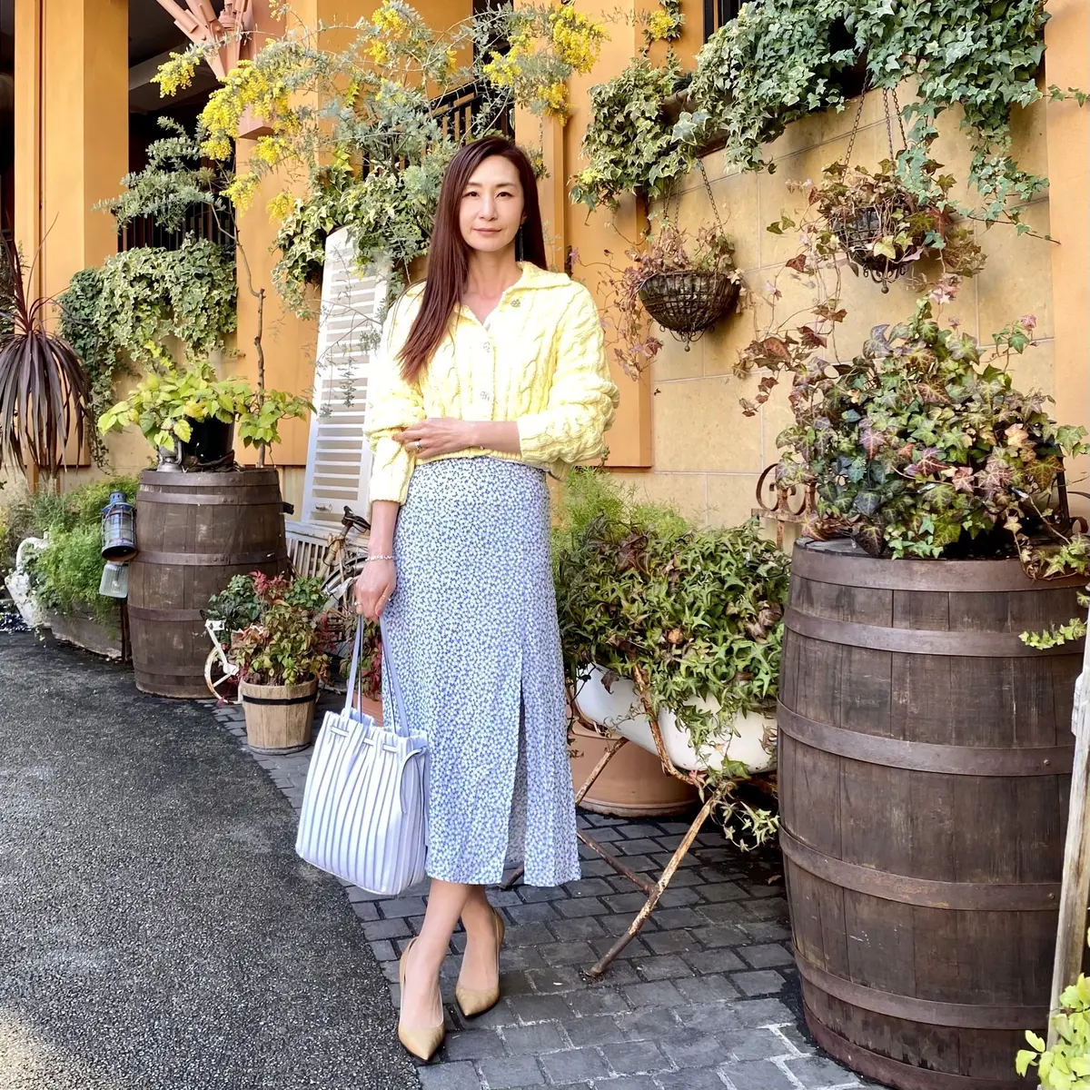 ライトイエローのカーディガンにブルー系の小花柄スカート