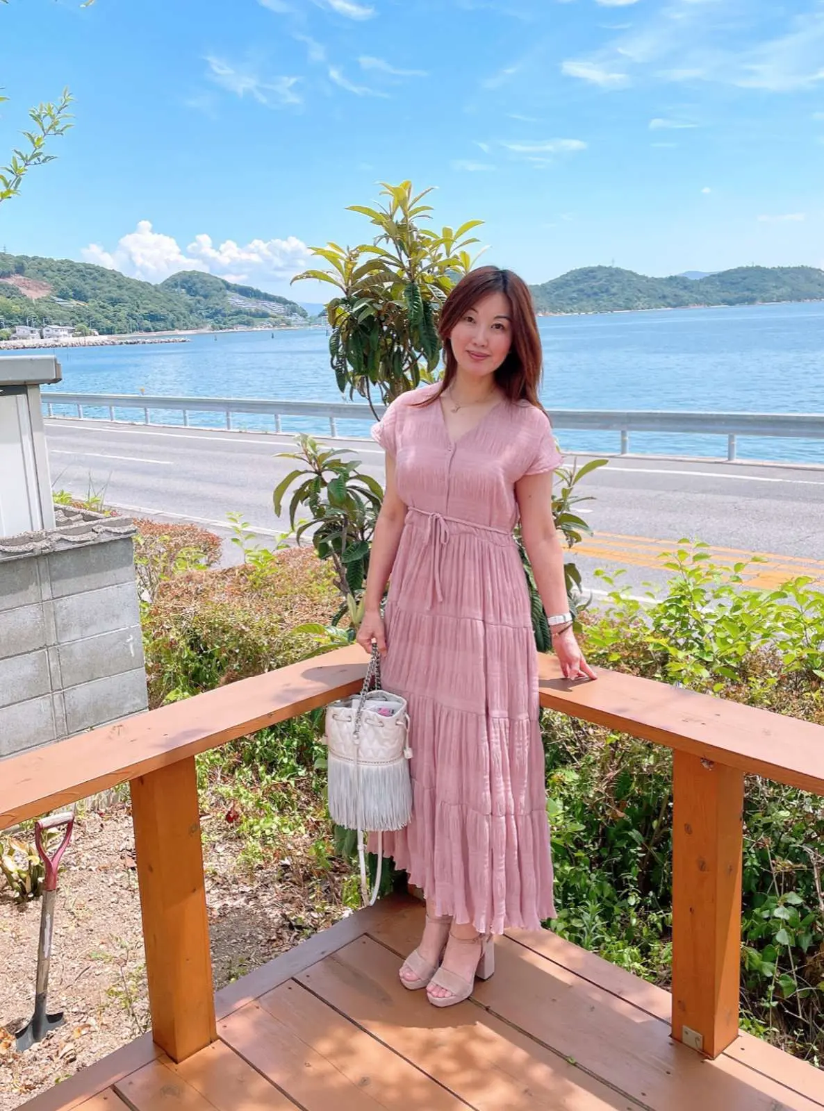 デッキ　ピンクワンピースの女性