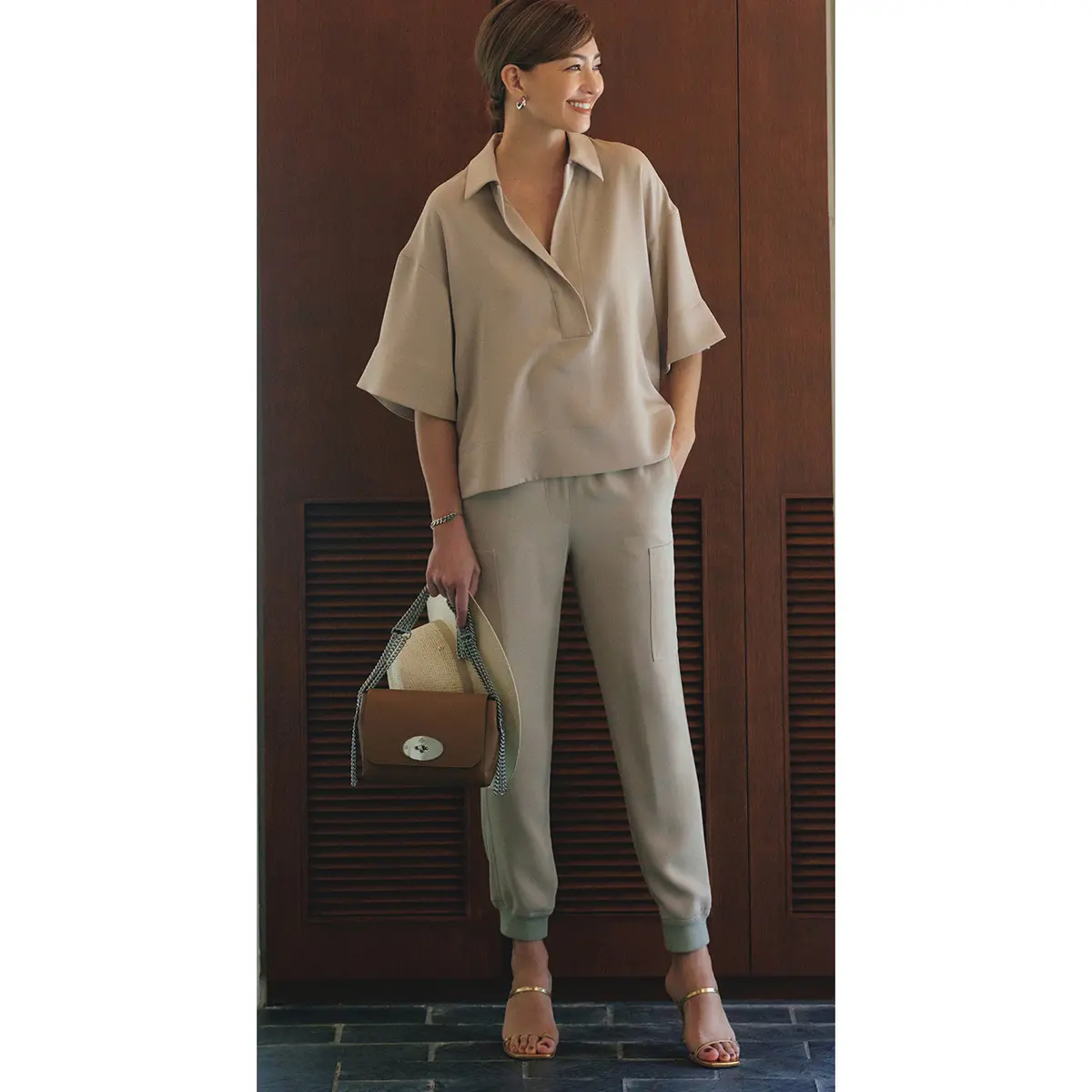 ベージュスキッパーシャツとパンツのセットアップを着たモデル・RINA