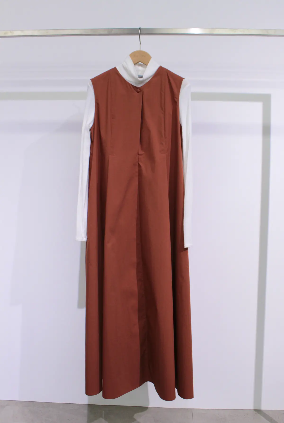 セオリーリュクス ブリックカラーのノースリーブワンピースの中に白タートルネックを合わせたスタイリング