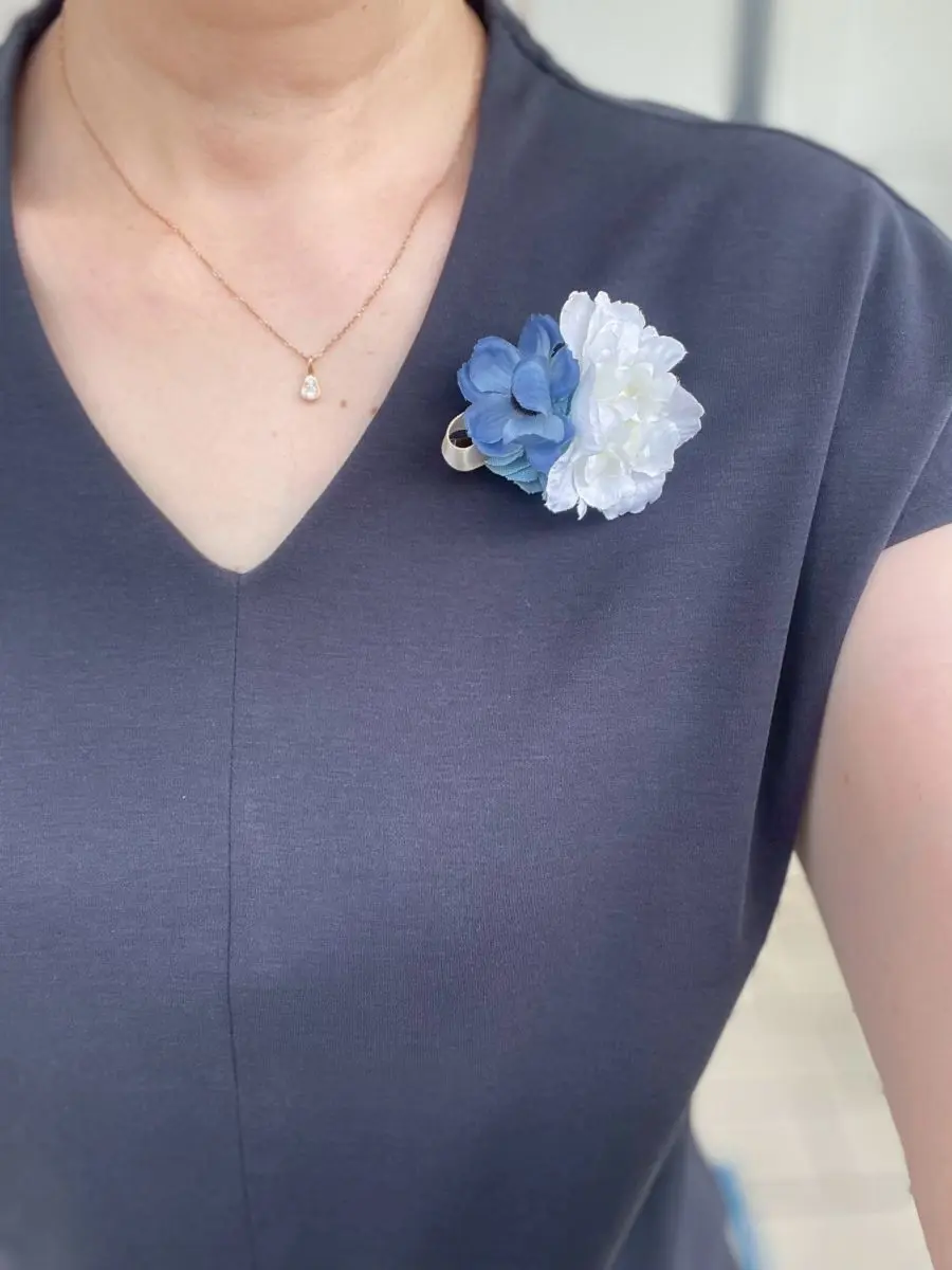 花のブローチとシンプルなTシャツ