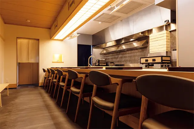 白壁に白木のカウンタ ーを配した明るい店内