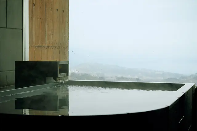 全客室にかけ流しの温泉を完備。無垢の石をくりぬいて作られた浴槽は肌当たりがスムース。