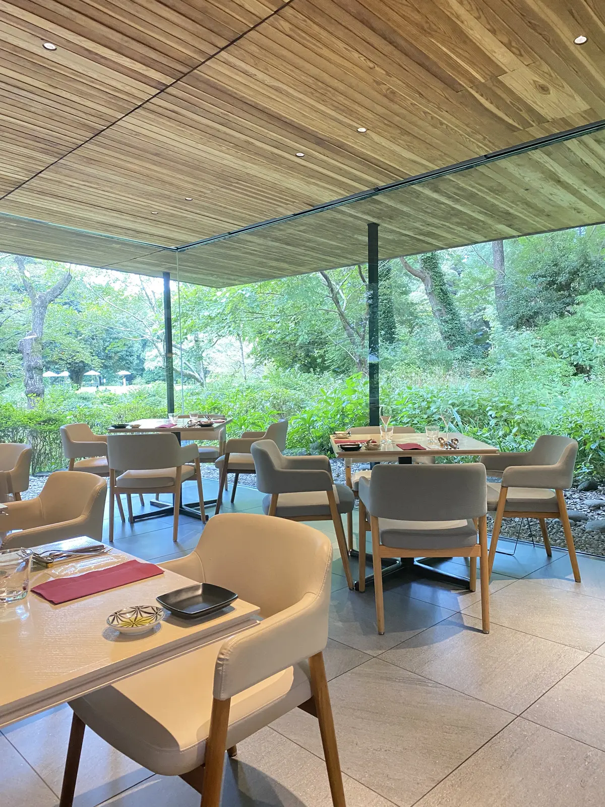 レストランTEIEN Restaurant comodoの店内。ガラス張りの窓から光が差し込む、開放感あふれる空間