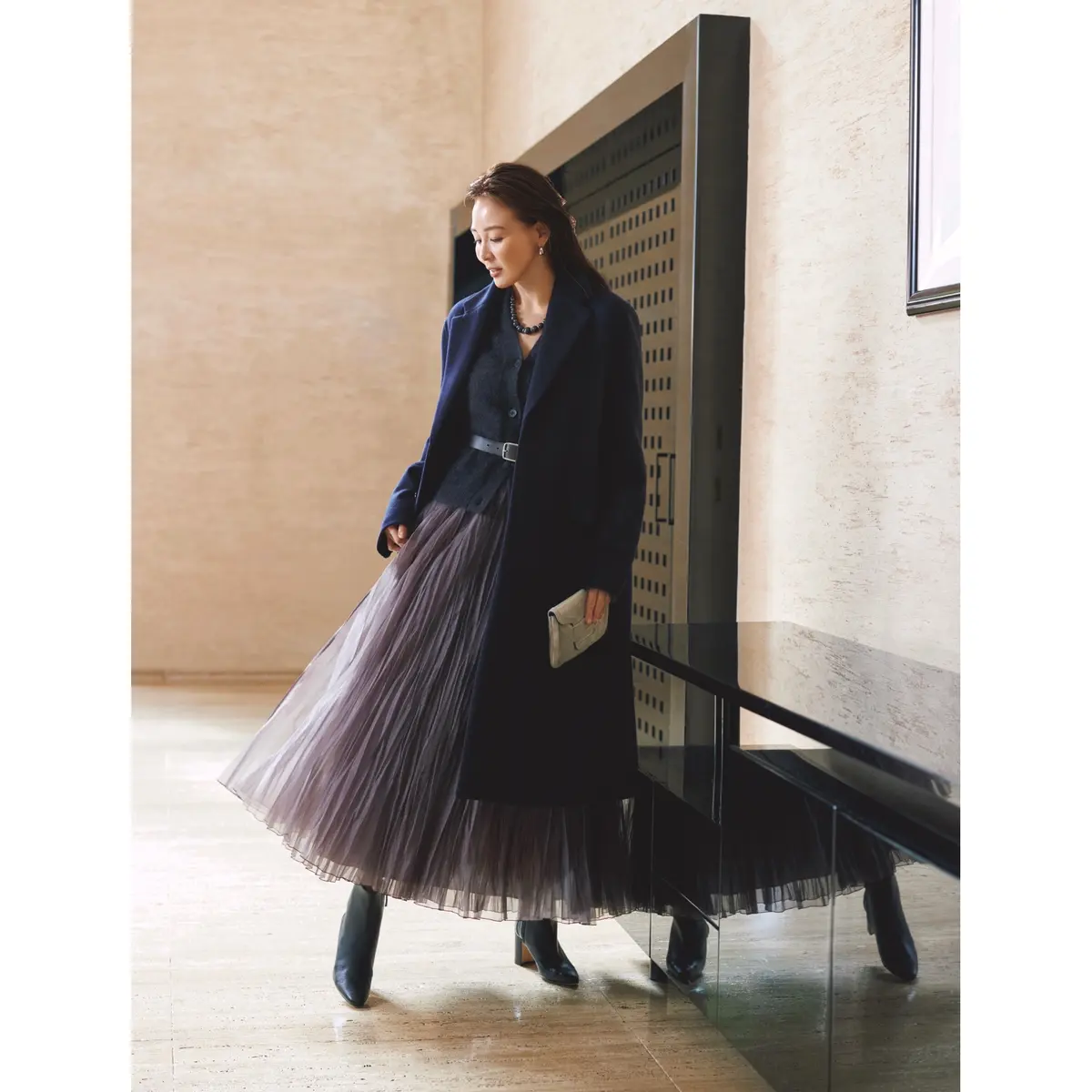 ネイビーのテーラードカラーコートの中に、グレーVネックカーディガンとグレーシフォンスカートを合わせたコーディネート　モデル・SHIHO
