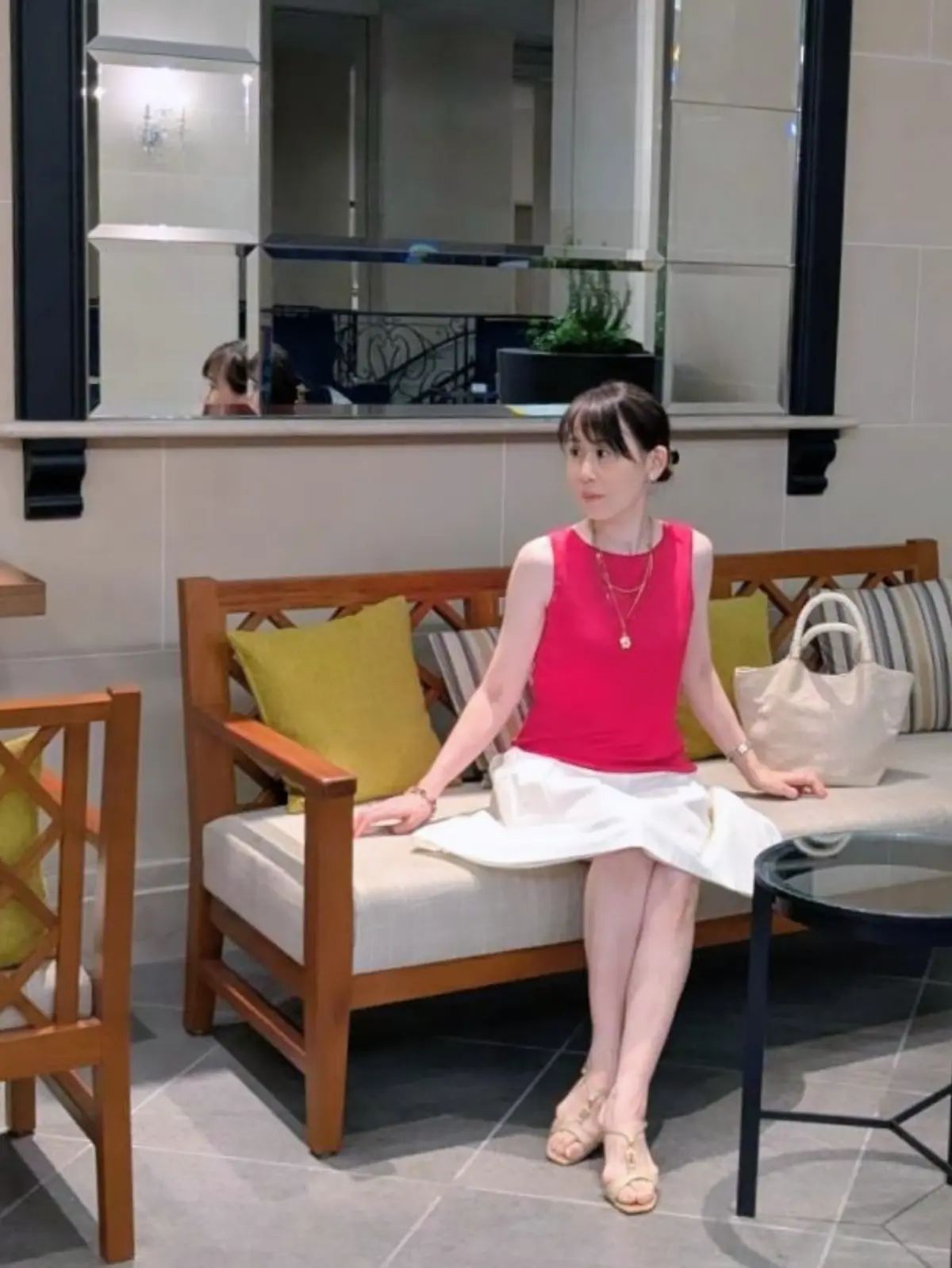 ラズベリーピンク色の鮮やかなノースリーブに真っ白なスカートで