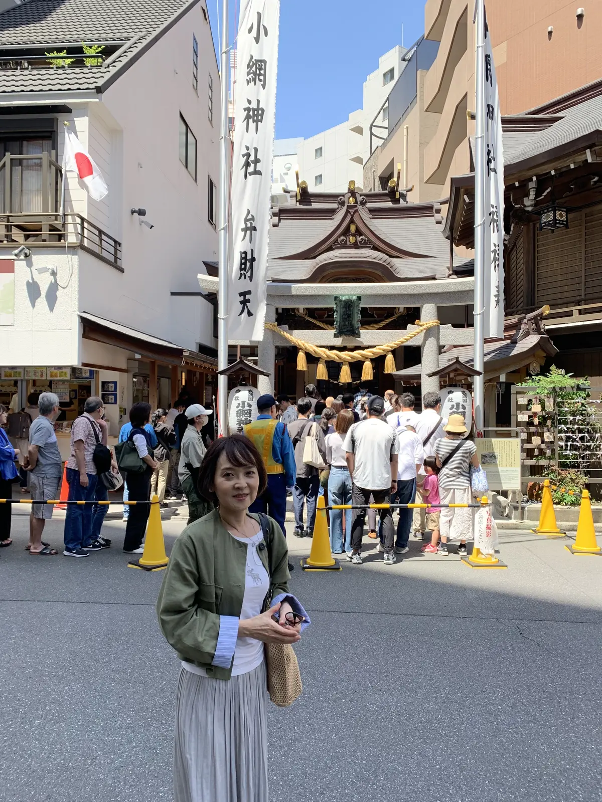小網神社をバックに写真撮影をする女性