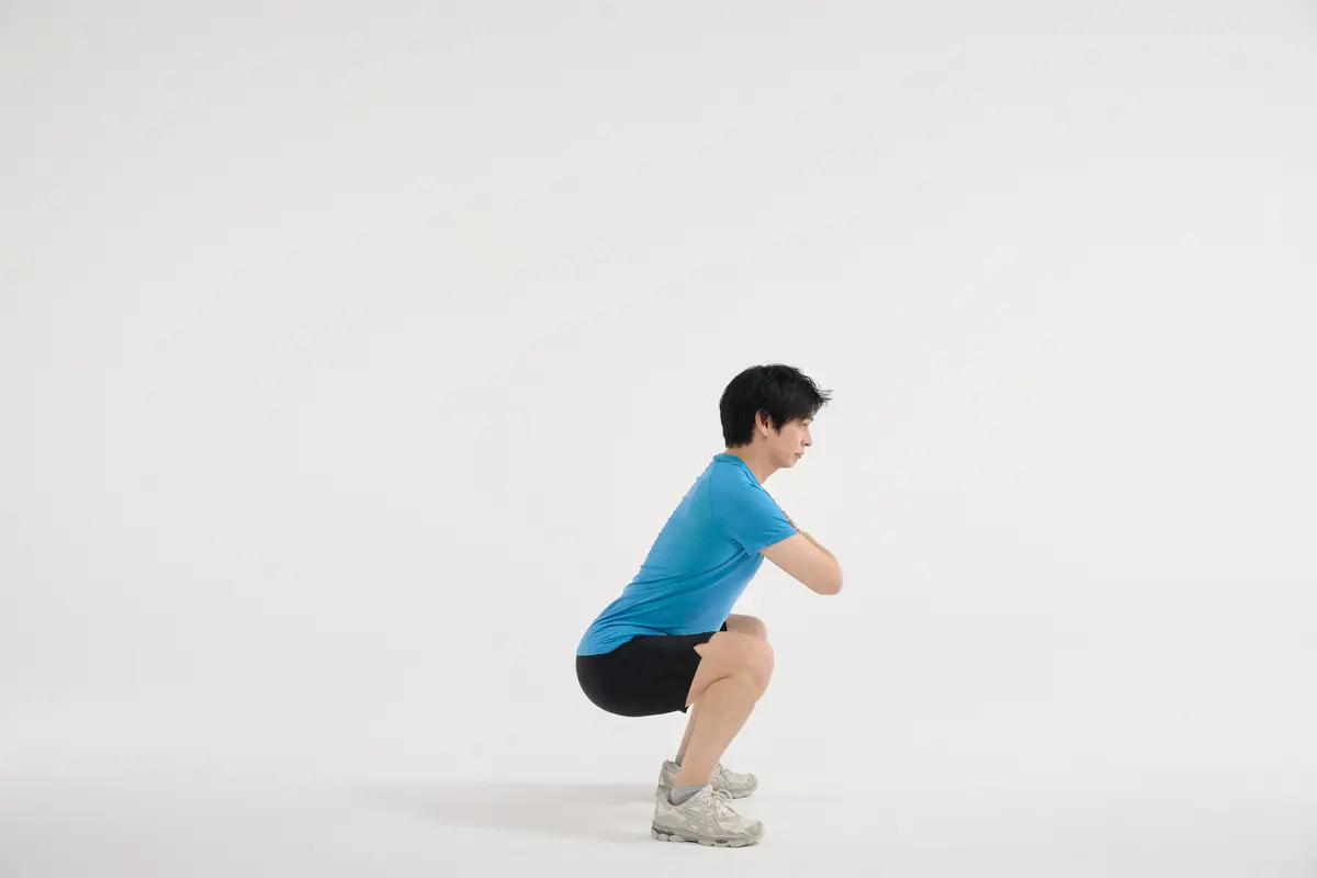 横から見たとき、背中からお尻までを一直線になるようにしゃがむ。太ももは床と平行になるのが理想的。