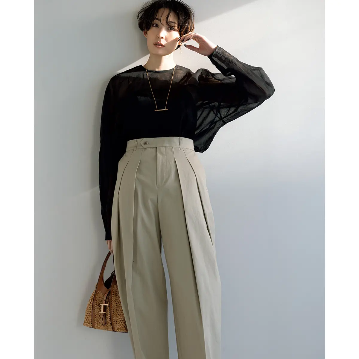 ブラックのシアーブラウスとベージュタックパンツのコーデ　モデル・LIZA