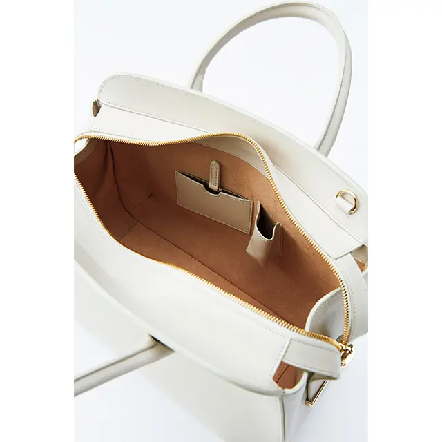 小物も見つけやすい 明るいベージュの内 側には、ジップポケ ットのほか、ハンド ミラーとリップポケ ットも。