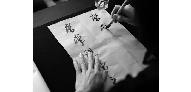 先生が書いた手本を見ながら書いていく。4文字からスタートし、今は5〜6文字を練習中