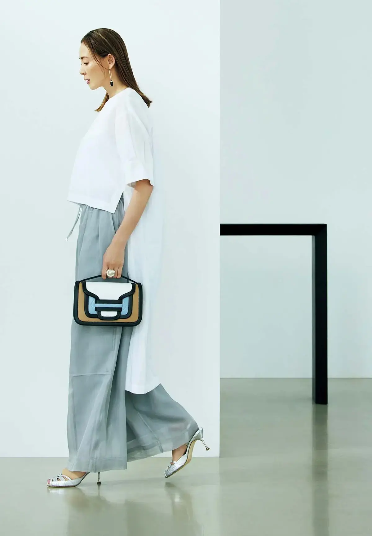 ブルーグレーのシアーパンツをきっぱりとした白で支え、澄みきったモードを主張