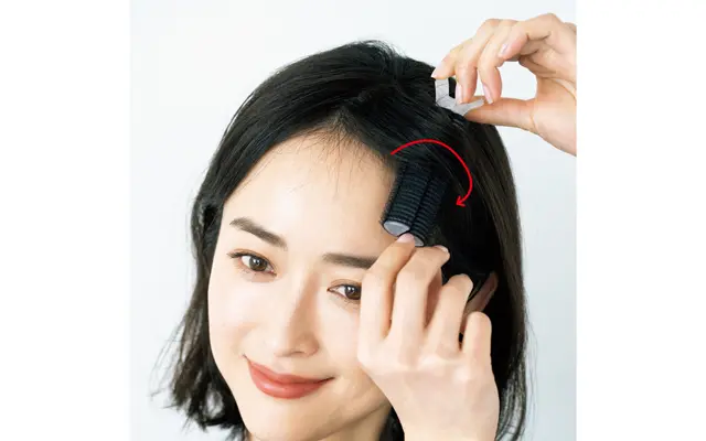 前髪を分けたい方向と反対側に流し、まずクリップ部分で毛先をはさむ。