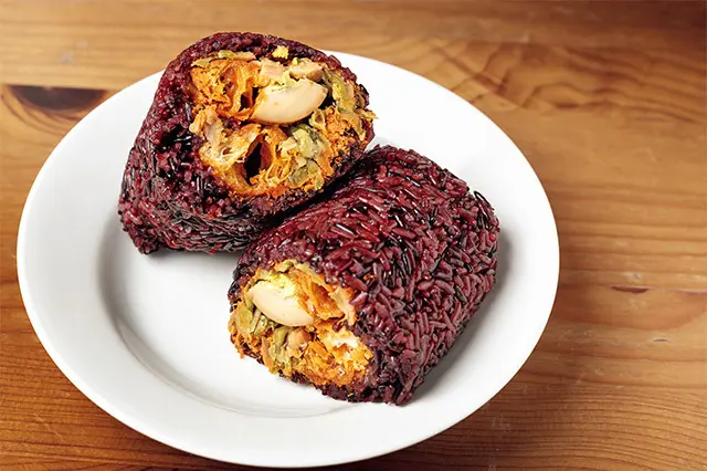 日本のおにぎり以上定食未満の栄養＆ボリューム満点。肉そぼろ、漬け物、切り干し大根、揚げパン、煮卵など具だくさんな招牌紫米飯糰（ザオパイズーミーファントァン）NTD55。午前中早めに売り切れることが多い