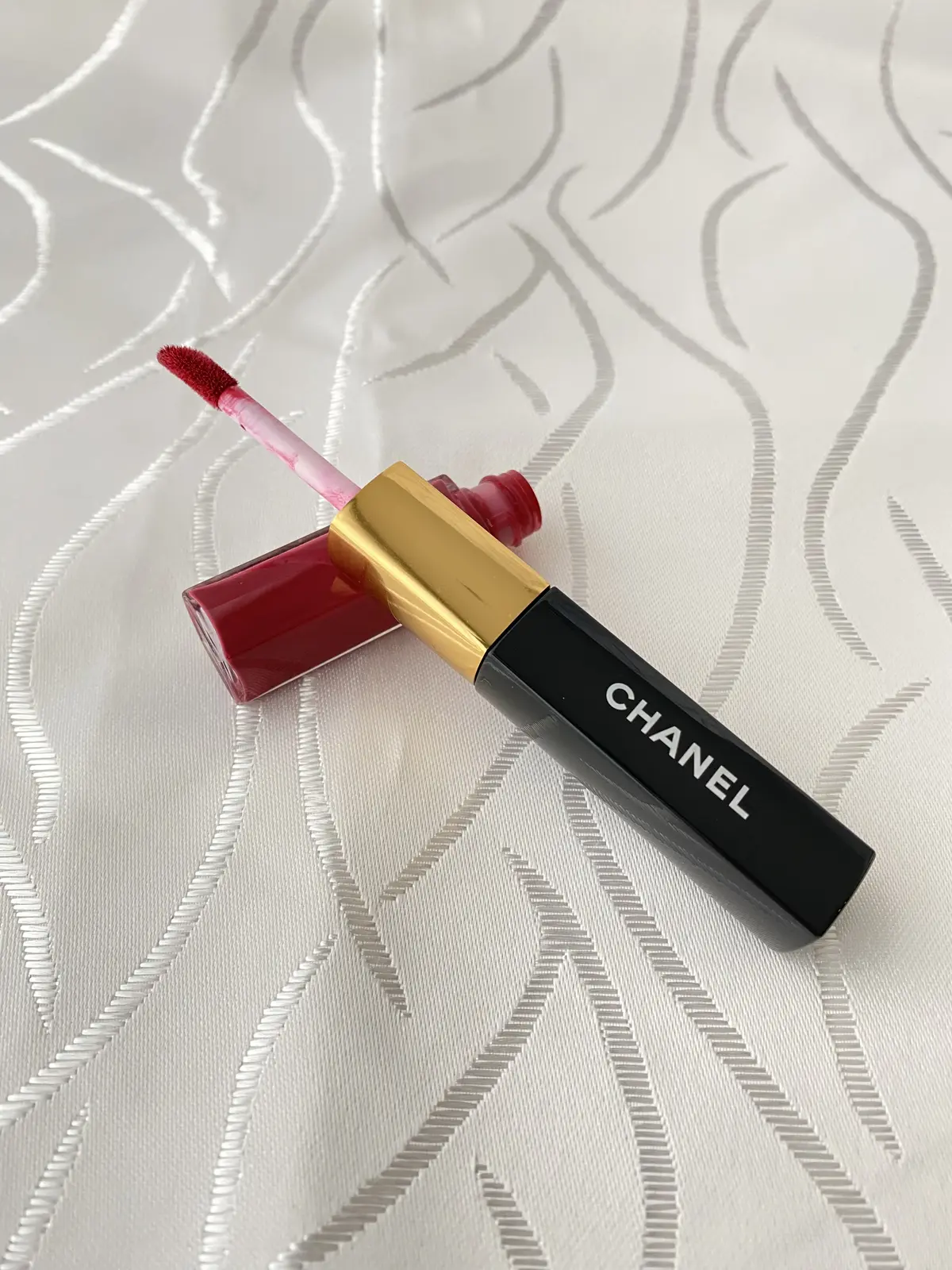 CHANELのルージュ デュオ ウルトラ トゥニュ#43、赤いリキッドルージュとチップアプリケーターのアップ写真