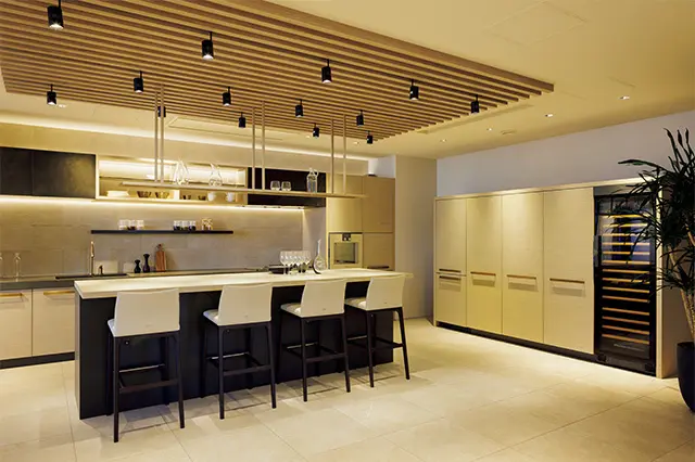 別荘を想定し、カウンタートッ プの厚み、扉の色、取っ手にいた るまで特注で作られたフルオー ダーキッチン。最近はこのよう なベージュ系の木目の扉に黒系 のカウンタートップ、ゴールド 金物の組み合わせが人気だとか
