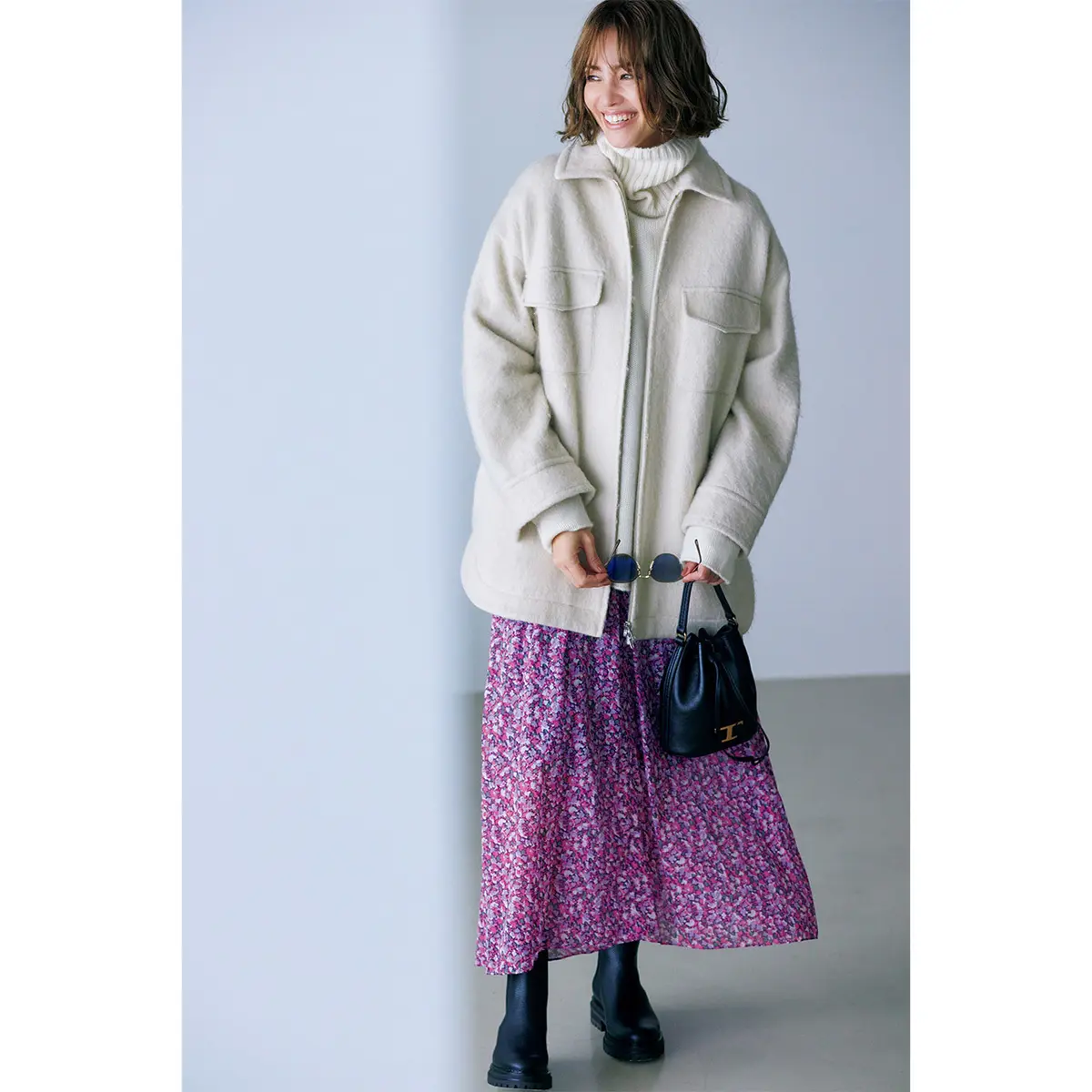 オフ白のブルゾンとピンク系小花柄スカートのコーデを着たモデル・RINA